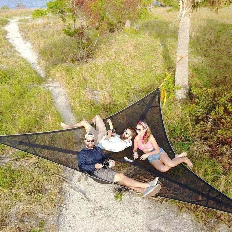 People relaxing in black aerial hammock