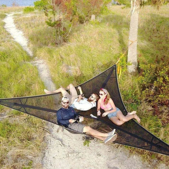 People relaxing in black aerial hammock