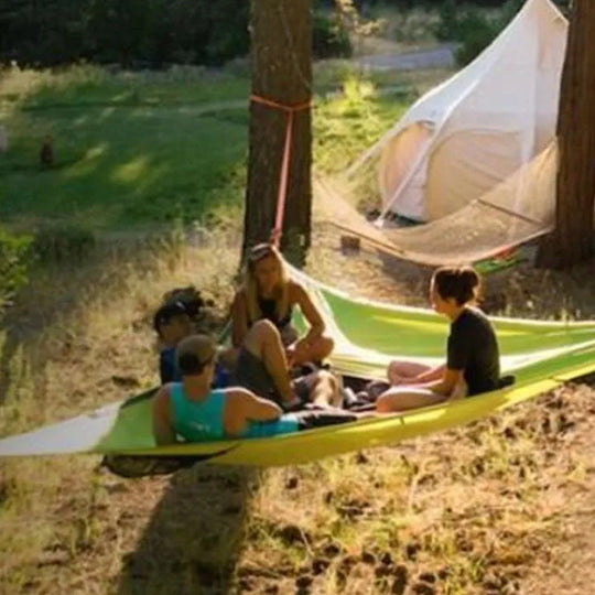 Friends relaxing in green aerial hammock