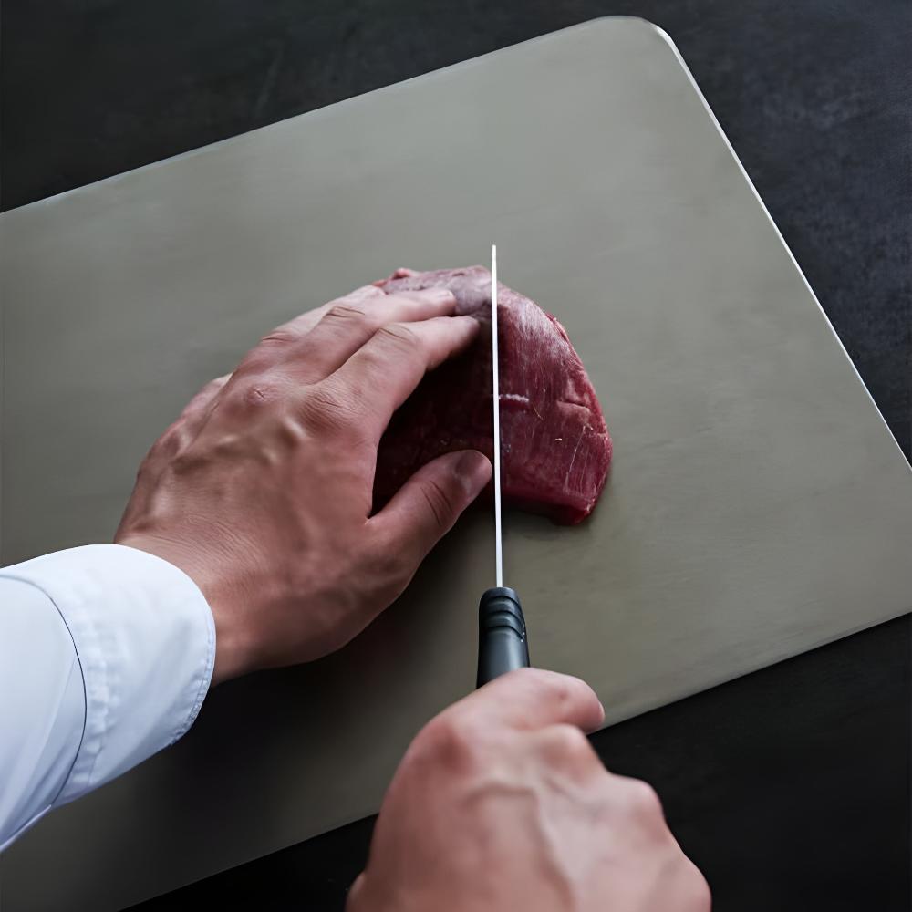 Slicing meat on the hygienic stainless steel cutting board