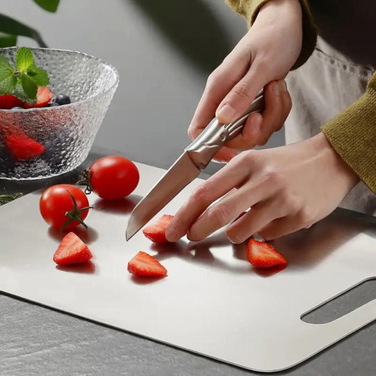 Cutting strawberries on the stainless steel board