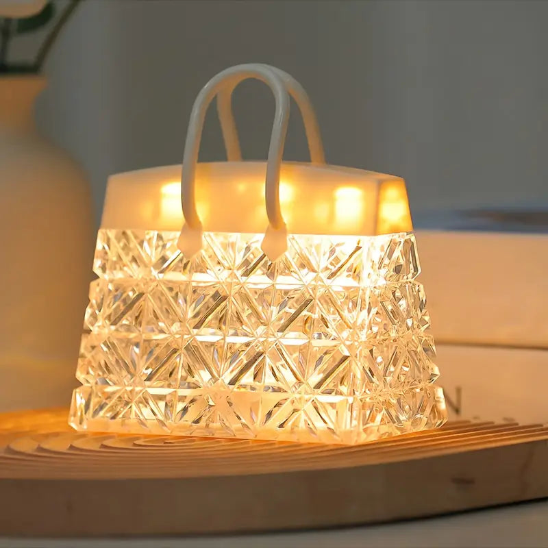 Handbag-shaped glass LED table lamp glowing warmly