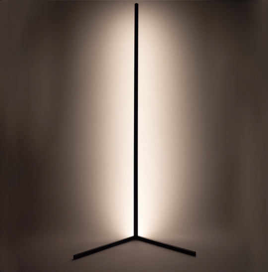 Black corner floor lamp glowing warm