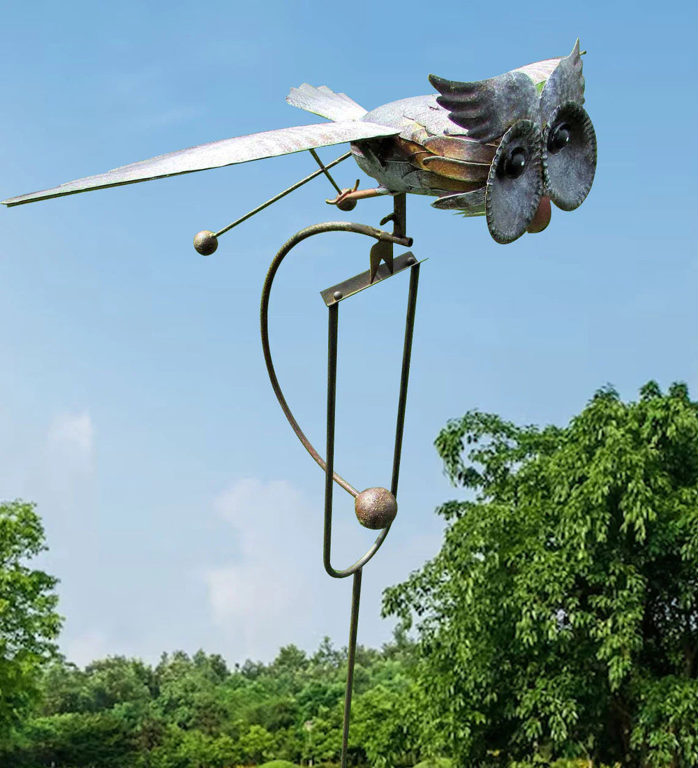 Standing owl metal wind spinner in garden
