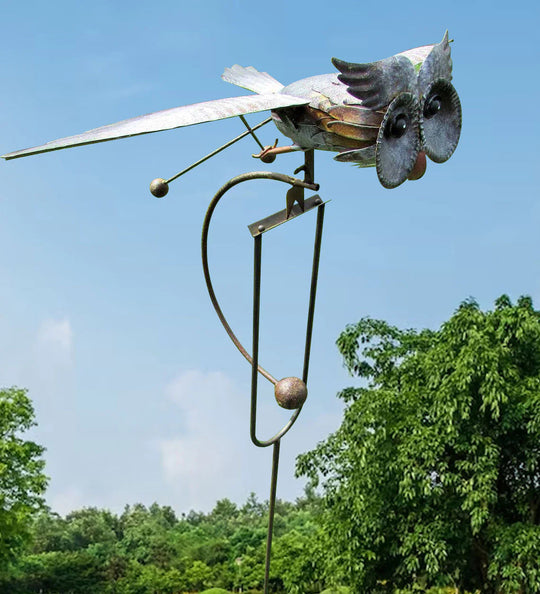 Standing owl metal wind spinner in garden