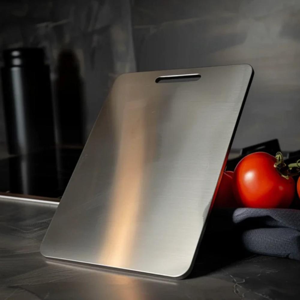 Brushed stainless steel cutting board standing on a kitchen counter