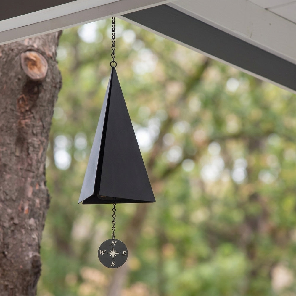 Wind bell hanging from a porch beside a tree