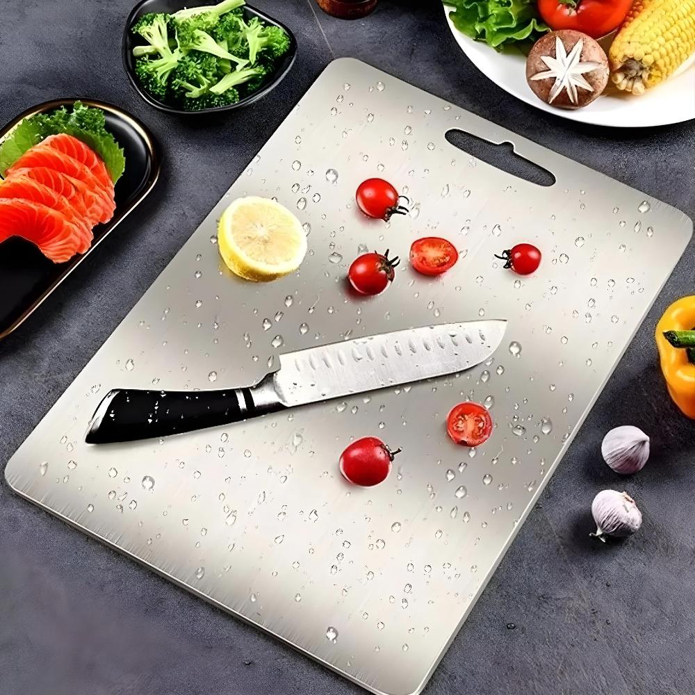 Stainless steel cutting board with knife and fresh vegetables