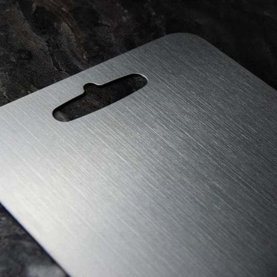 Close-up of the brushed stainless steel cutting board with hanging hole