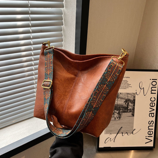 Brown leather shoulder bag with patterned strap