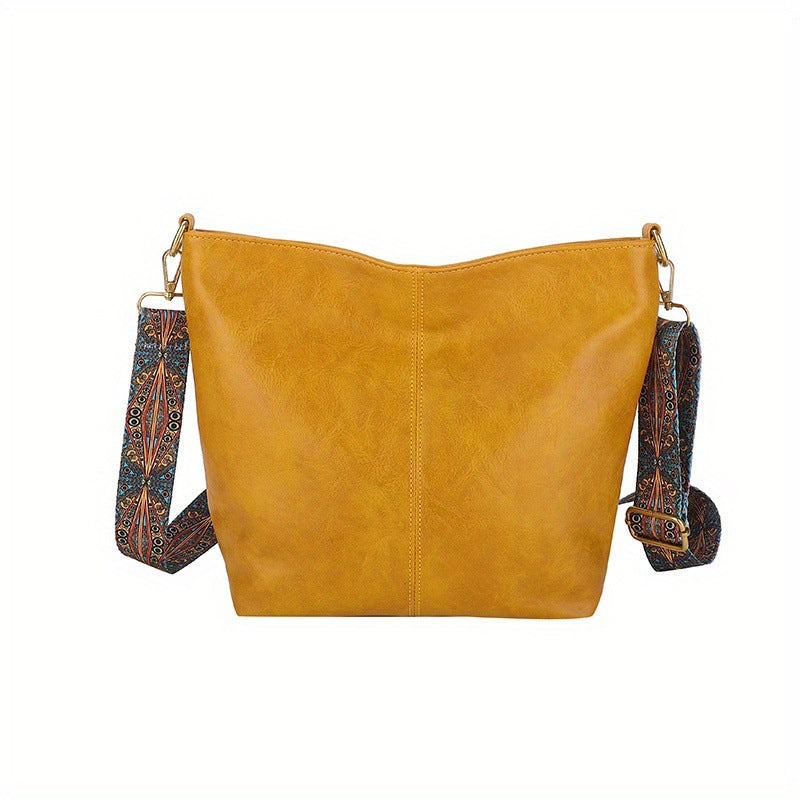 Yellow-orange leather shoulder bag with patterned strap