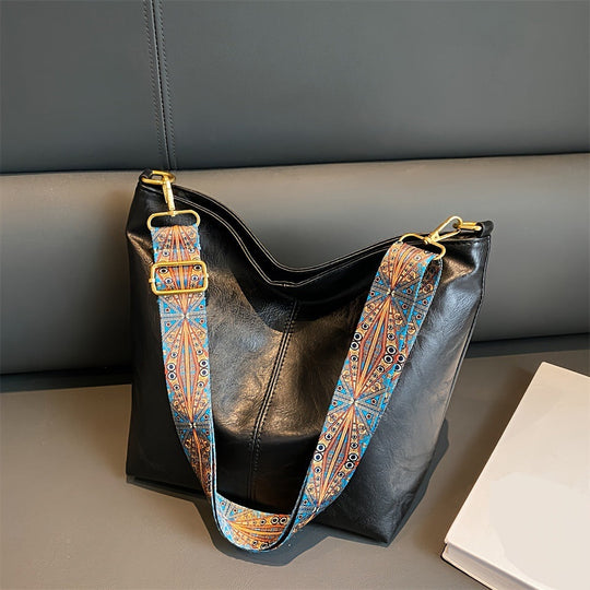 Black leather shoulder bag with patterned strap