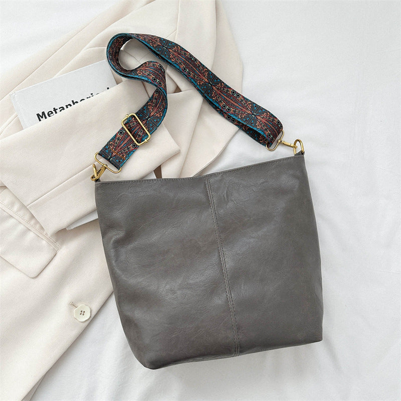 Gray leather shoulder bag with patterned strap