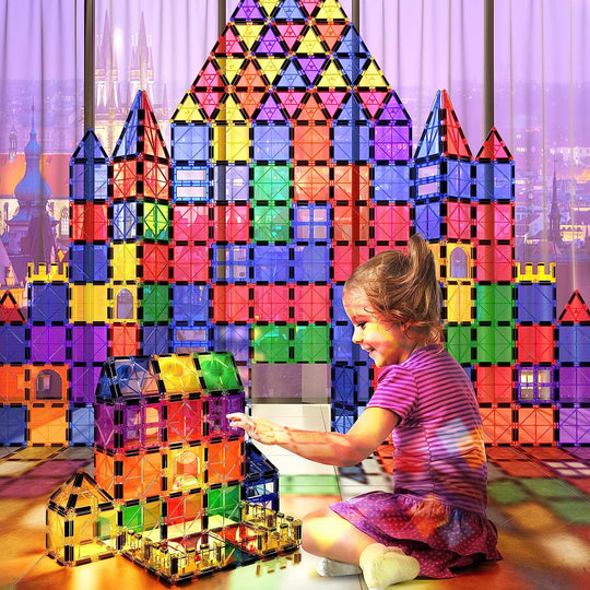 Child building with rainbow magnetic tiles