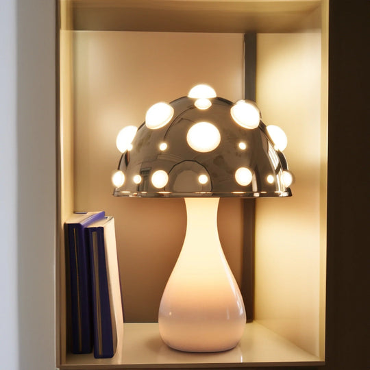 Gold mushroom lamp on a shelf with books