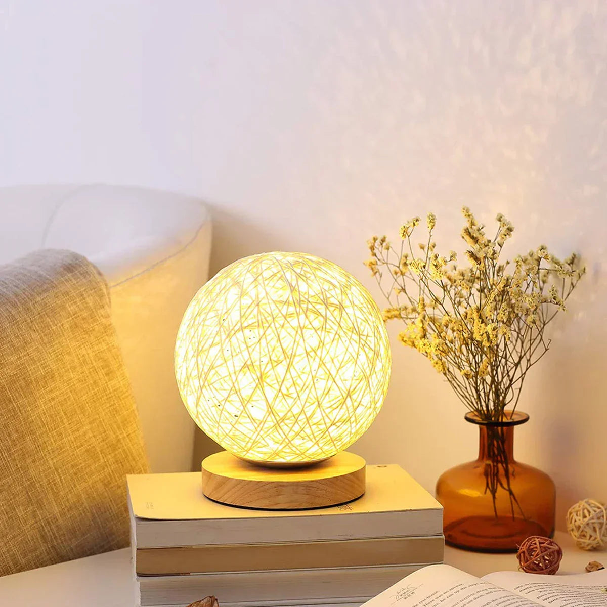 Rattan sphere table lamp glowing on a bedside table