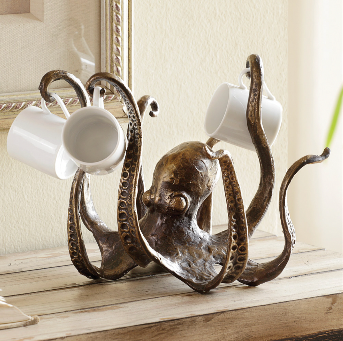 Bronze octopus mug holder displaying white mugs