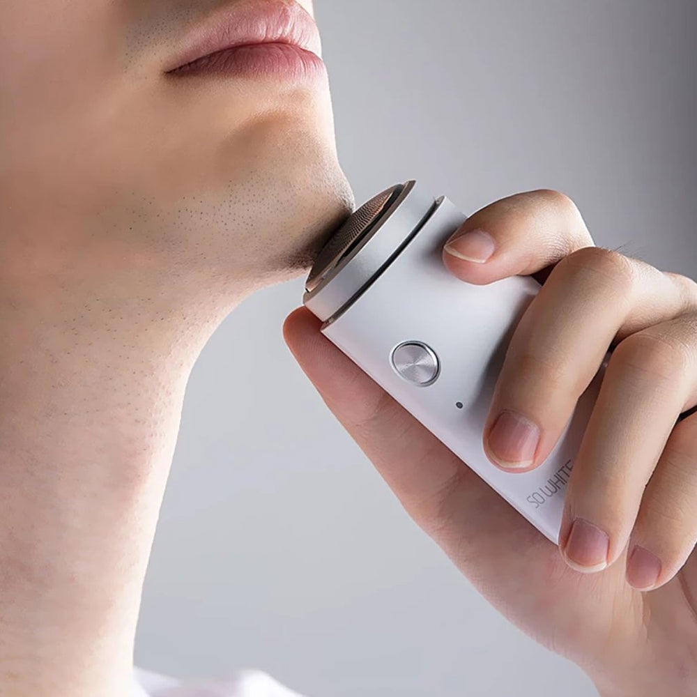 Man shaving with mini electric shaver