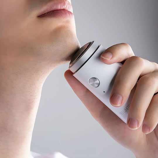 Man shaving with mini electric shaver
