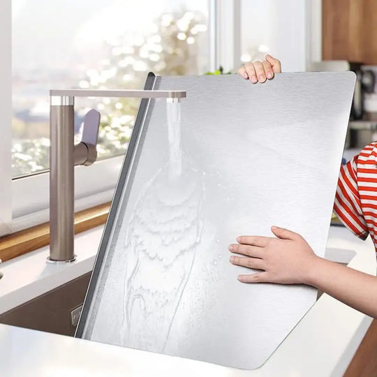 Holding the stainless steel cutting board by the sink