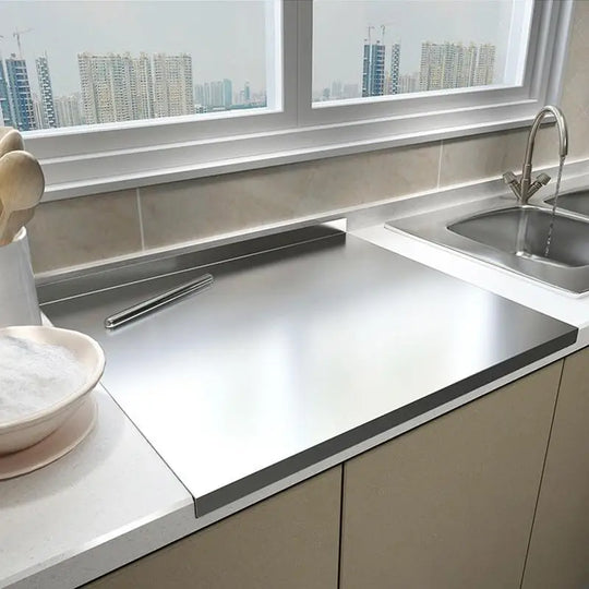 Stainless steel cutting board installed over a kitchen counter
