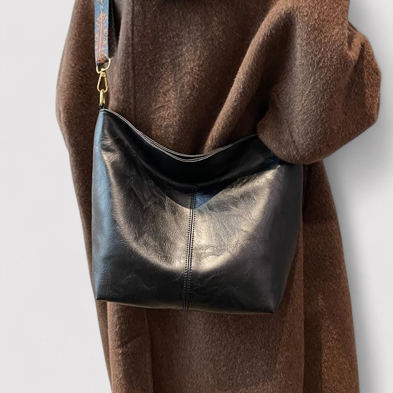Black leather shoulder bag with patterned strap