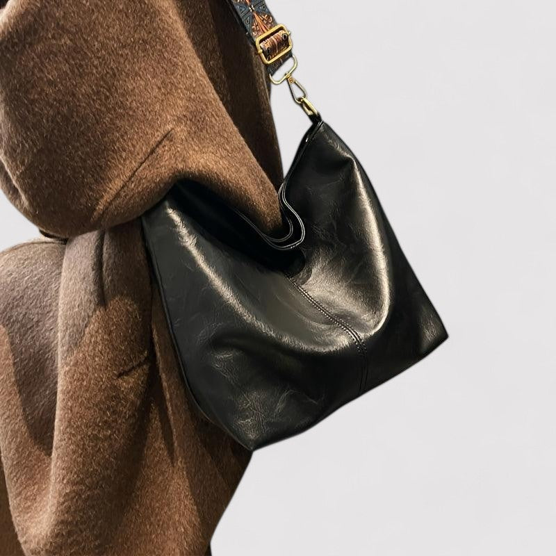 Black leather shoulder bag with patterned strap